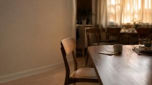 An untouched drink and an isolated empty chair symbolize the loneliness and hidden pain caused by mockery.